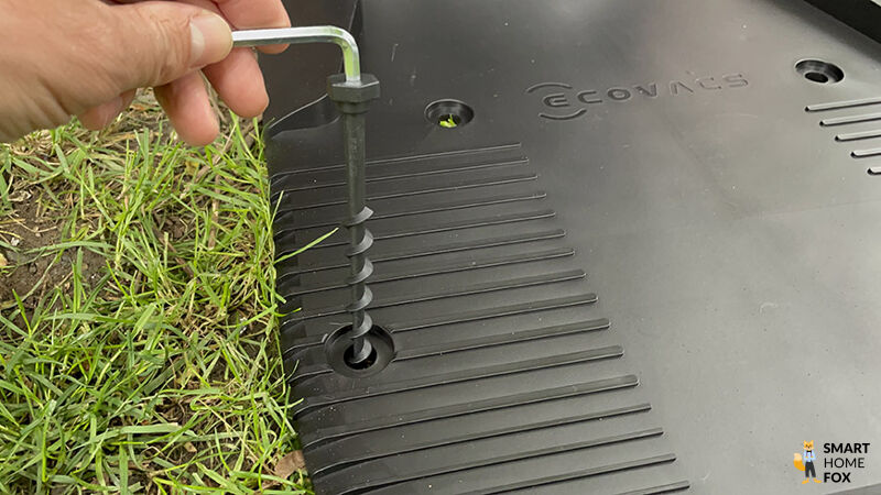 Die Bodenanker des ECOVACS Goat G1-800 Mähroboters ohne Begrenzungskabel zum Verankern der Ladestation werden gezeigt.